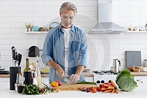 Happy handsome man cooking in kitchen at home