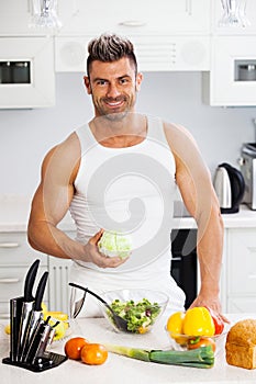 Happy handsome man cooking in kitchen at home.