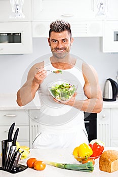 Happy handsome man cooking in kitchen at home.