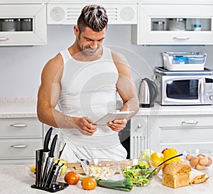 Happy handsome man cooking in kitchen at home.