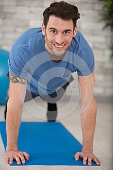 happy handsome man doing push ups at home