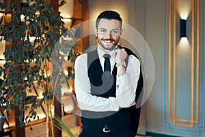 Happy handsome man in elegant suit in modern luxury interior