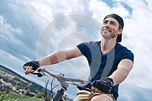 Joyful man, in active recreation on a mountain bike.