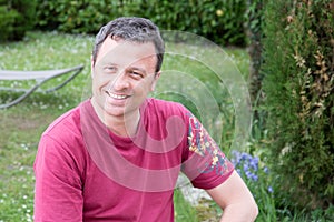 Happy handsome man outdoor in home garden