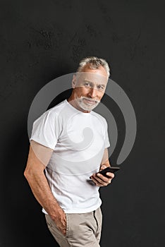 Happy handsome mature old man using mobile phone.