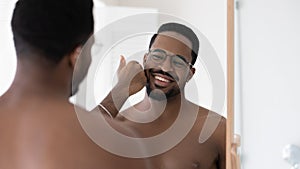 Happy handsome mixed race Black guy in glasses touching stubble photo