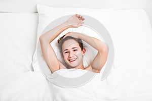 Happy handsome toothy smiling child boy lying bed and resting