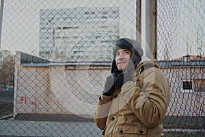 Happy handsome young man in cap with earflaps. The young man in the fur hat