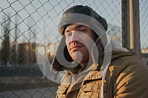 Happy handsome young man in cap with earflaps. The young man in the fur hat