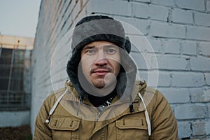 Happy handsome young man in cap with earflaps. The young man in the fur hat