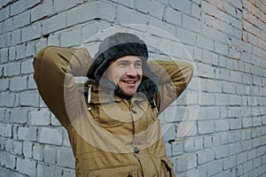 Happy handsome young man in cap with earflaps. The young man in the fur hat