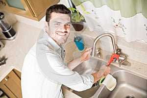 Happy handyman fixing a leaky faucet