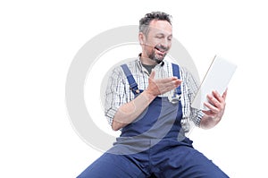 Happy handyman wathcing something funny on tablet