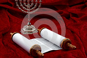 Happy Hanukkah, religious spirituality and praying concept theme with menorah and Torah scrolls isolated on red velvet background