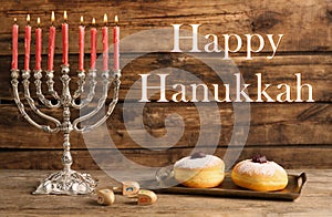 Happy Hanukkah. Silver menorah, sufganiyot and dreidels on wooden background