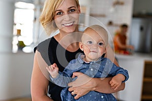 Happy family indoors. Portrait of beautiful mother with cute baby playing smiling together.