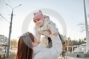 happy harmonious family outdoors. mother throws baby up, laughing and playing in the summer