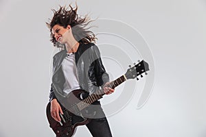 Happy head banging woman guitarist playing guitar photo