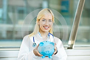 Happy health care professional, doctor, nurse holding piggy bank