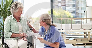 Happy health care professional sharing positive news with older patient. Laughing senior woman talking to a nurse while