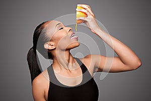 Happy healthy black asian woman squeezing orange juice fruit