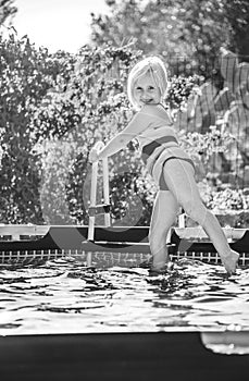 Happy healthy child in swimwear standing in swimming pool