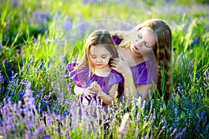 Happy healthy family concept. A young beautiful woman with her little cute daughter walking in the wheat gold field on a