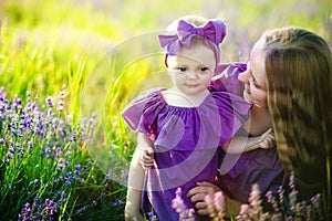 Happy healthy family concept. A young beautiful woman with her little cute daughter walking in the wheat gold field on a