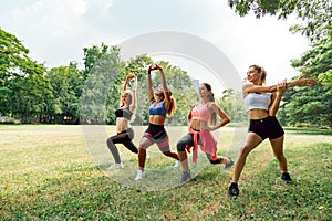 Happy healthy four beautiful young teenagers woman training and stretching for warming up before exercise in the park. fitness,