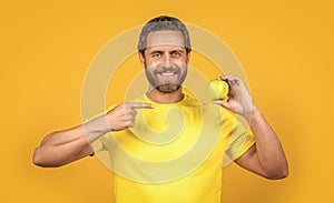 happy healthy man with vitamin fruit on background. healthy man with vitamin fruit in studio