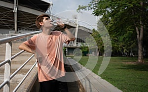 Happy healthy men drinking water from bottle after workout exercise. Sports, nutrition bottle, and men athletes drink liquid for