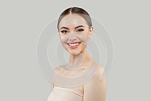 Happy healthy model woman with beautiful skin and cute smile on white background, studio portrait. Facial treatment, skin care