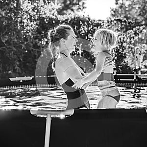 Happy healthy mother and child in swimming pool playing