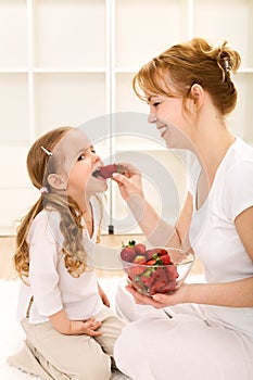 Happy healthy people eating fresh strawberries