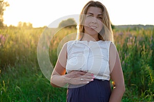 Happy healthy pregnancy and maternity. Portrait of pregnant young caucasian woman wearing long blue dress posing in park