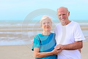 Happy healthy retired elders couple enjoying vacation on the beach