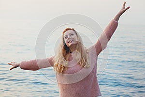 happy healthy smiling young blonde woman enjoying nature with hands wide open, carefree