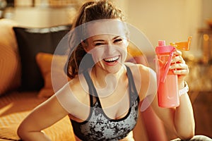 Happy healthy sports woman with shaker with fitness supplements