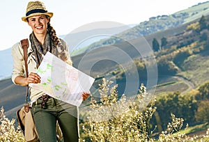 Happy healthy woman hiker with bag hiking in Tuscany with map