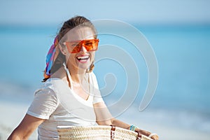 Happy healthy woman on seacoast in orange sunglasses