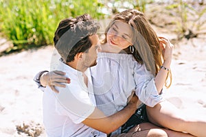 happy heterosexual couple hugging at sandy