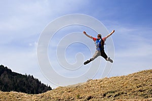 Happy hiker is jumping up