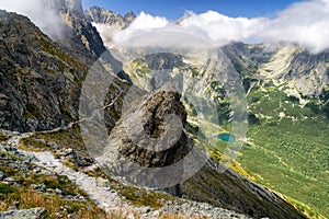 Happy hiker on the rock in mountains