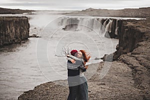 Happy hipster couple kissing in love with view of Iceland Selfoss waterfall