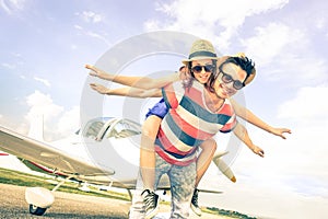 Happy hipster couple in love on airplane travel honeymoon trip