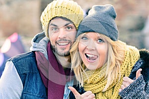 Happy hipster couple in love take a selfie photo during sunny day in autumn. Best friends with winter clothes sharing free time.