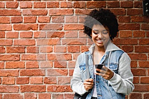 Happy hipster girl looking at her smartphone