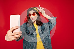 Happy hipster girl making funny selfie with horns