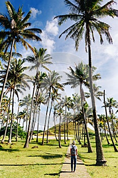 Happy hipster gitl walking bitween palm trees on Anakena beach, Easter Island