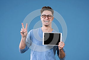 Happy hipster man with tablet computer giving victory sign